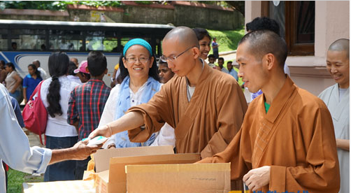 大乘佛教徒联合会的法师为斯里兰卡民众派发酸奶
